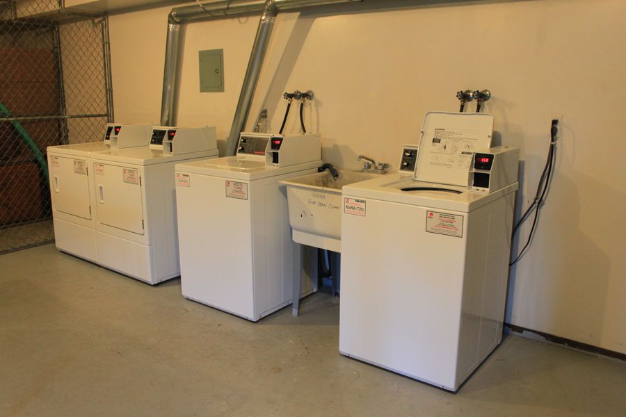 Card-operated Speed Queen commercial washers and dryers in an apartment laundry room